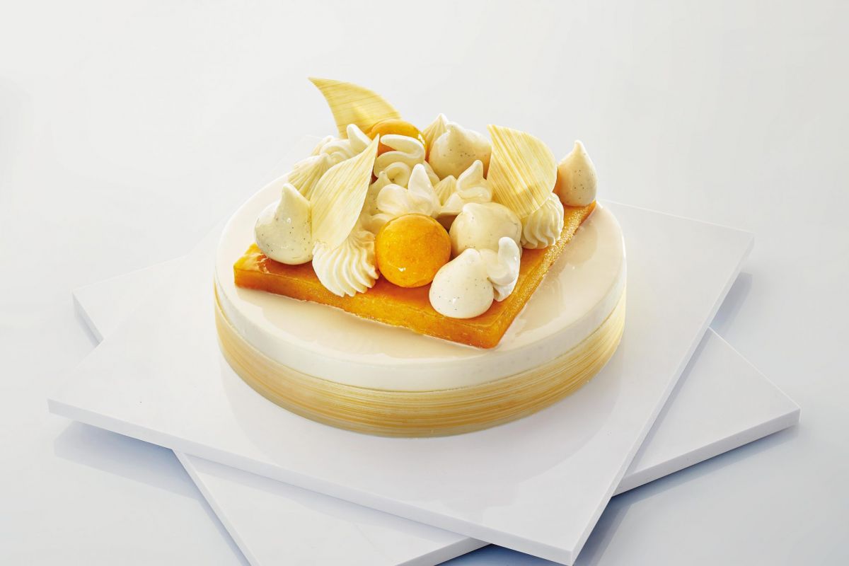 Torta Clementina con glassa, panna e decorazioni di cioccolato bianco. Dessert elegante.