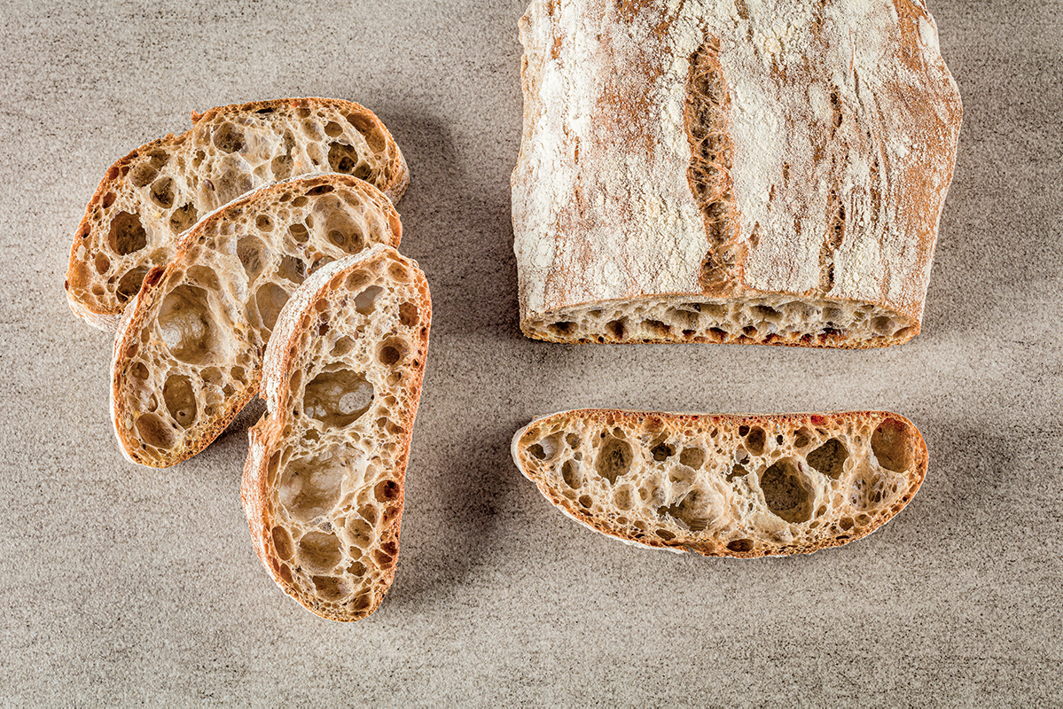 Pane bio Molino Merano. Pagnotta e fette di pane artigianale con alveolatura.