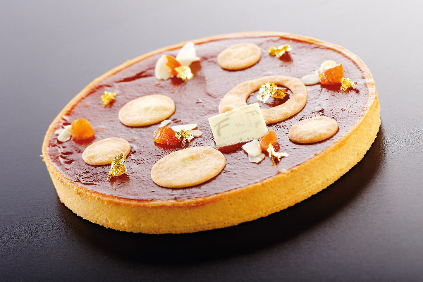 Crostata con confettura di albicocca di Valeria Fabbri. Dessert elegante con decorazioni dorate.