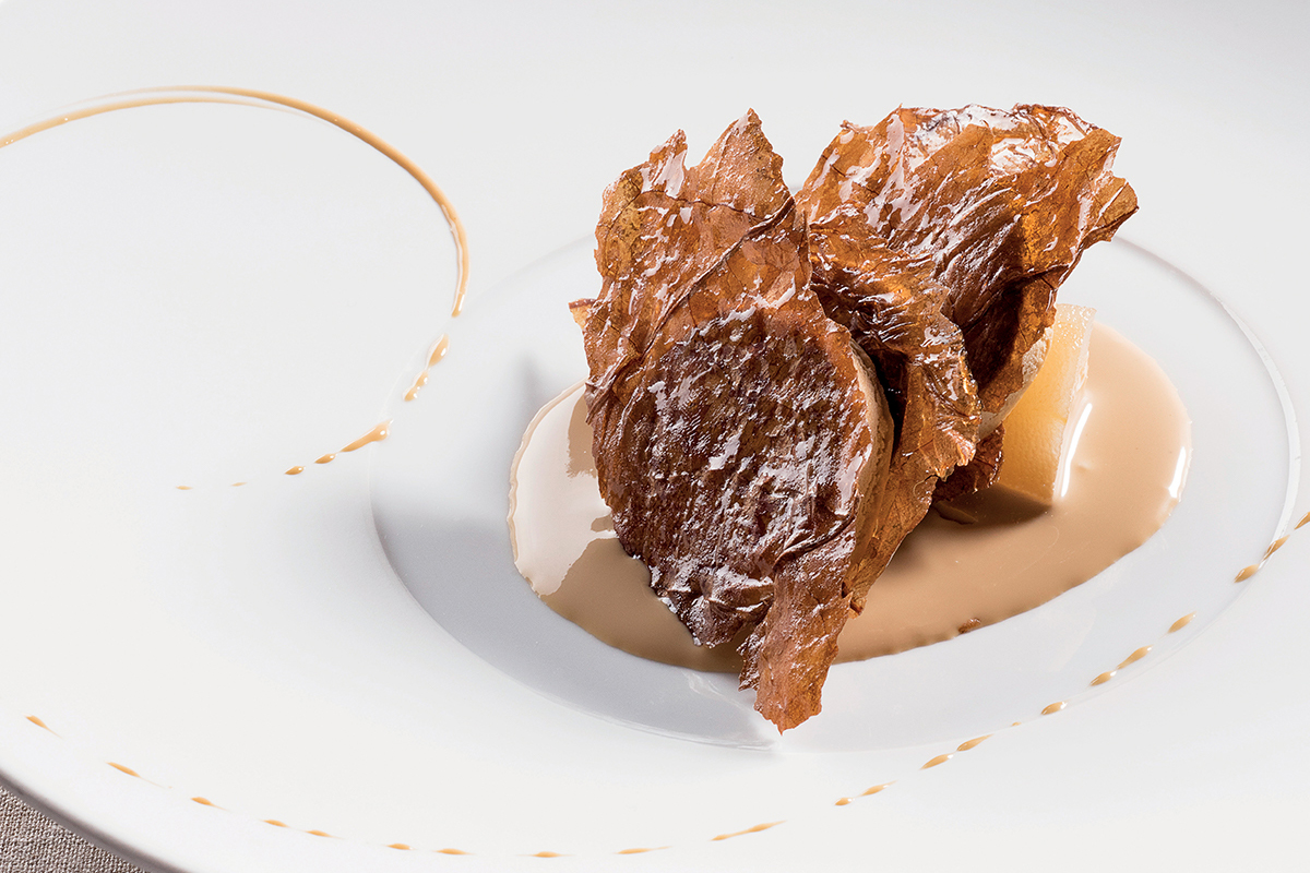 Parfait liquirizia con foglie di tabacco, pera speziata e crema caffè. Dessert gourmet, cucina creativa.