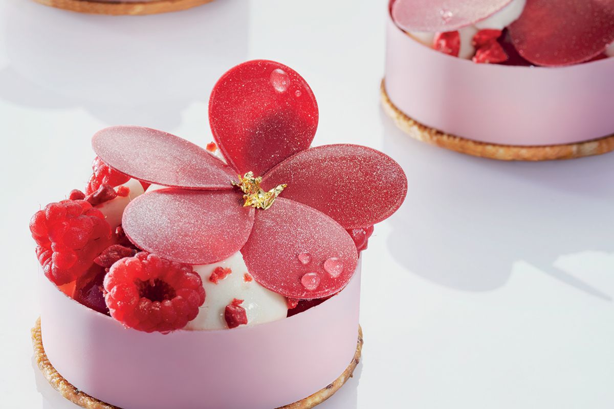 Dolce Fiore di Maggio: torta con lamponi freschi e decorazioni a forma di fiore rosa. Pasticceria artigianale.