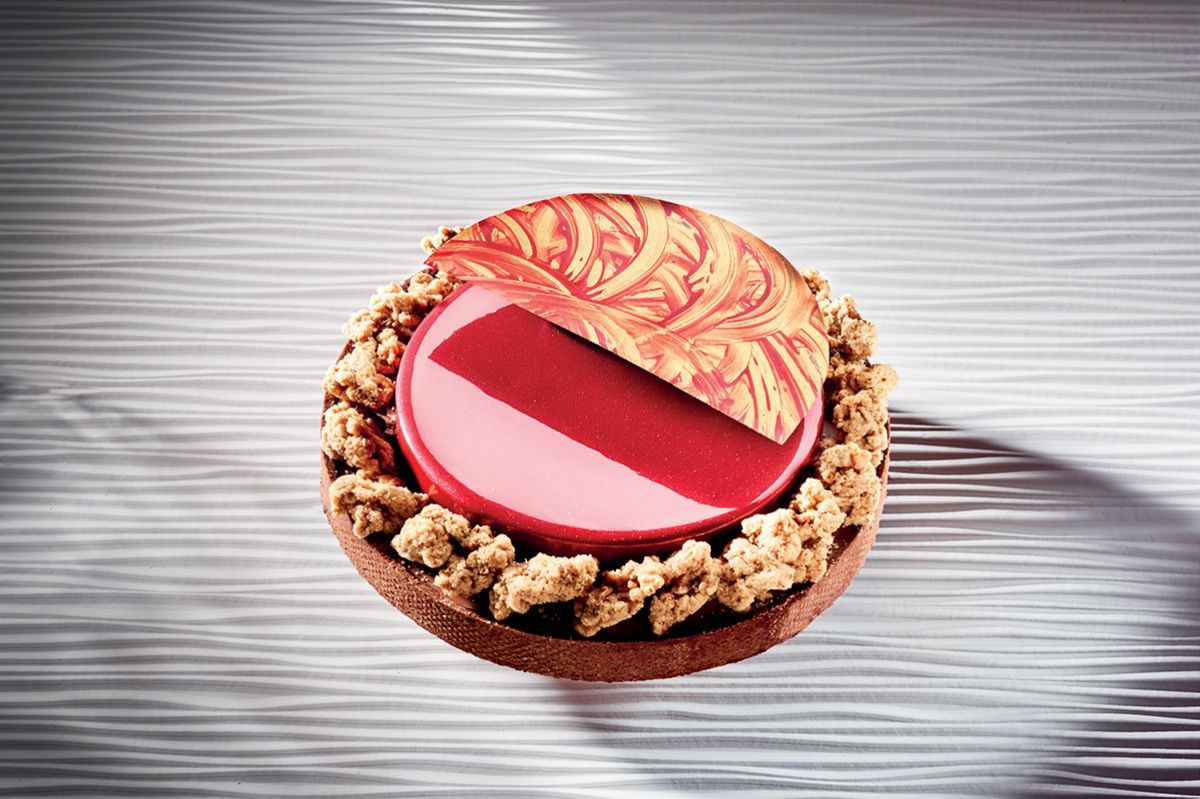 Crostata Vis: dessert elegante con glassa rossa, crumble e decorazione artistica.