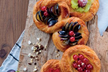 Sfogliotto con crema e frutta fresca. Pasticceria artigianale con prugne, ribes e uva. Dolci da forno.