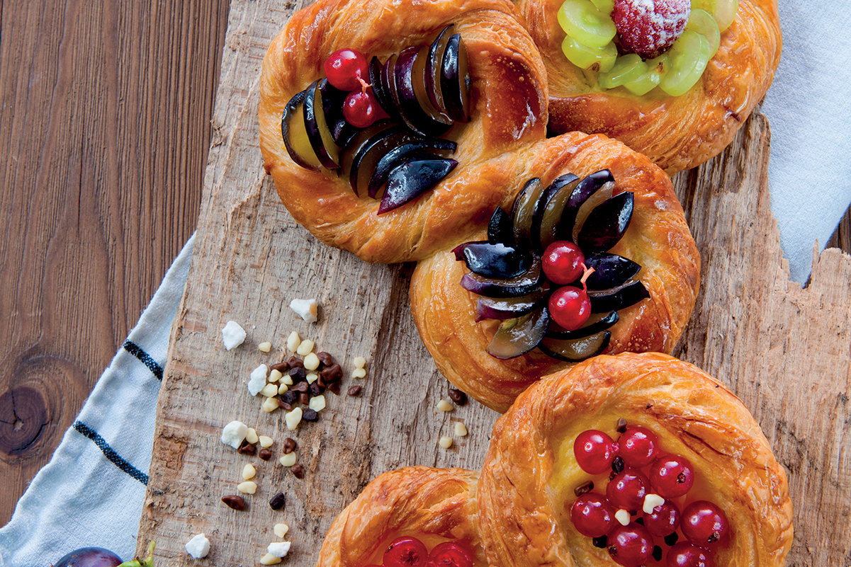 Sfogliotto con crema e frutta fresca. Pasticceria artigianale con prugne, ribes e uva. Dolci da forno.