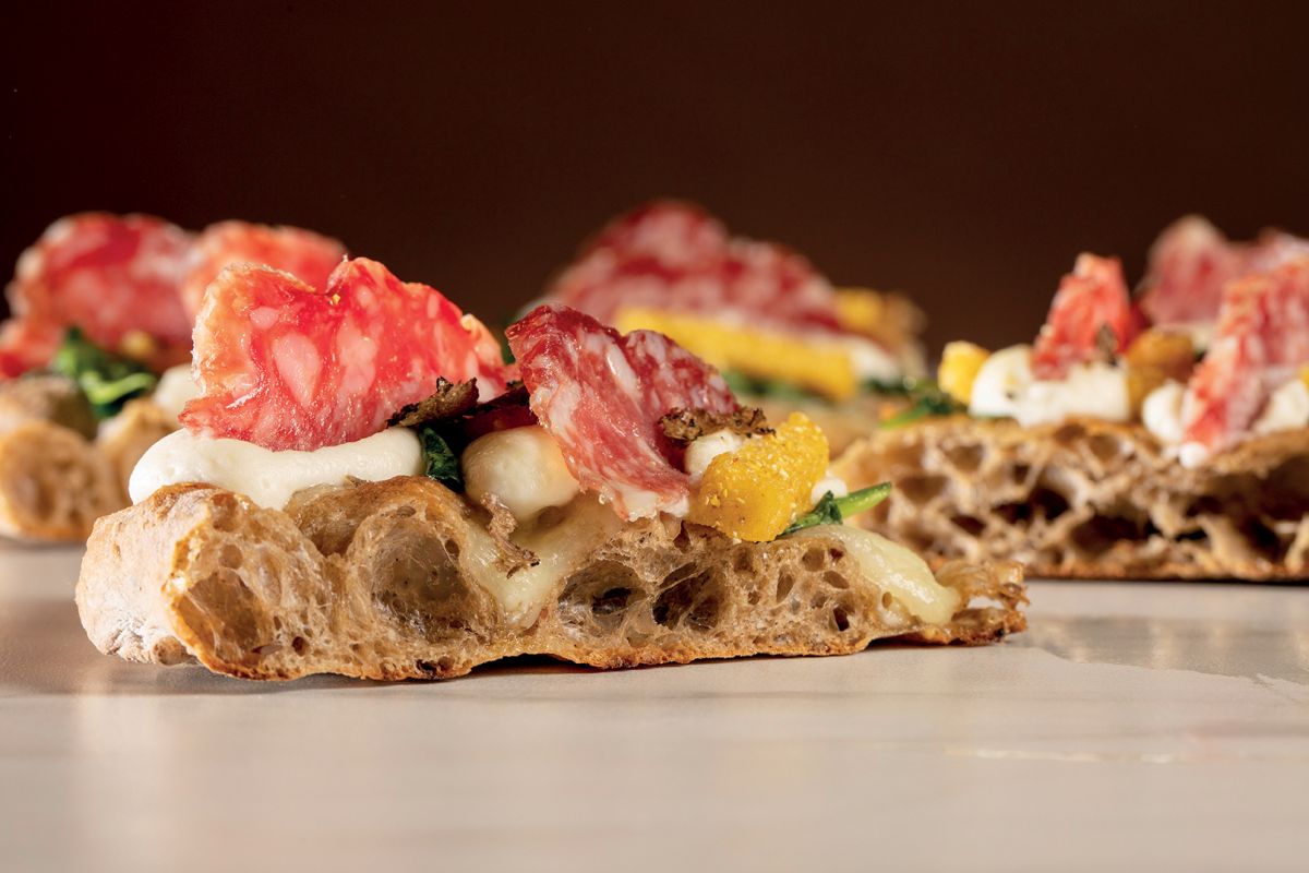 Scrocchiarella con salame delle Orobie. Ricetta con prodotti locali. Focaccia croccante, mozzarella e ingredienti freschi.