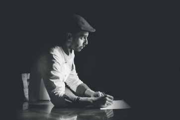 Andrea Guaglianone, artista: ritratto in bianco e nero mentre scrive. Arte e attitudine.