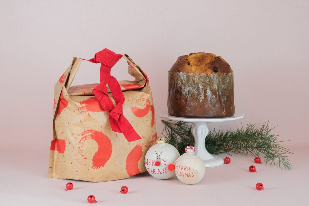 Sacchetto Ideabrill Esseoquattro con panettone artigianale. Decorazioni natalizie e nastro rosso.