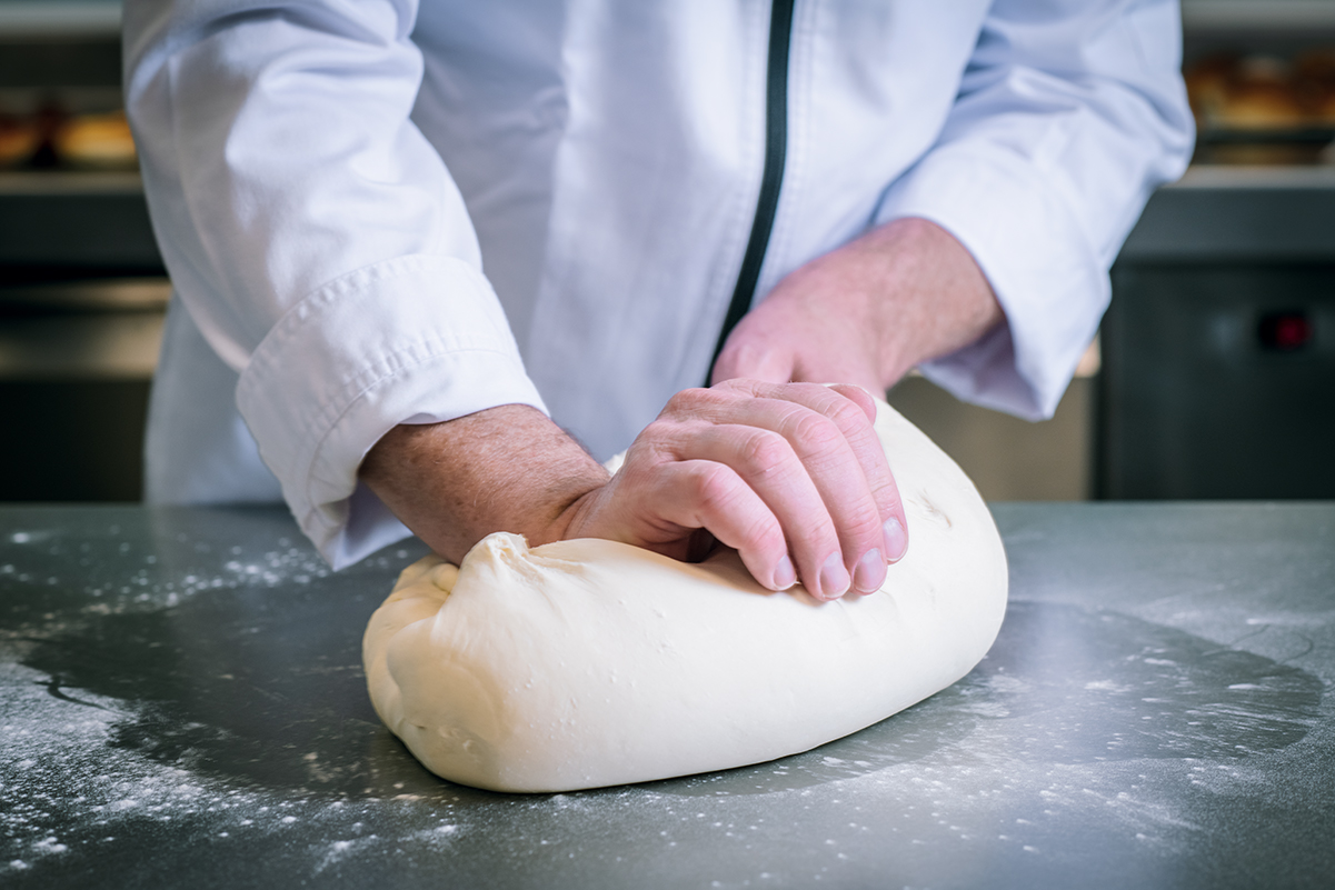 Impasto per pane artigianale. Mani di fornaio che lavorano la pasta. St-Allery Revolution.
