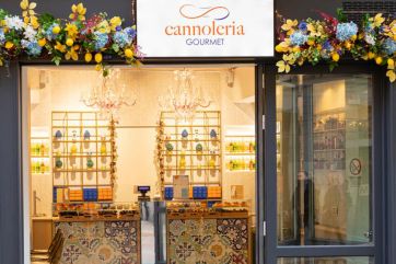 Vetrina Cannoleria Gourmet: cannoli siciliani, decorazioni floreali, lampadari. Dolcezza artigianale.