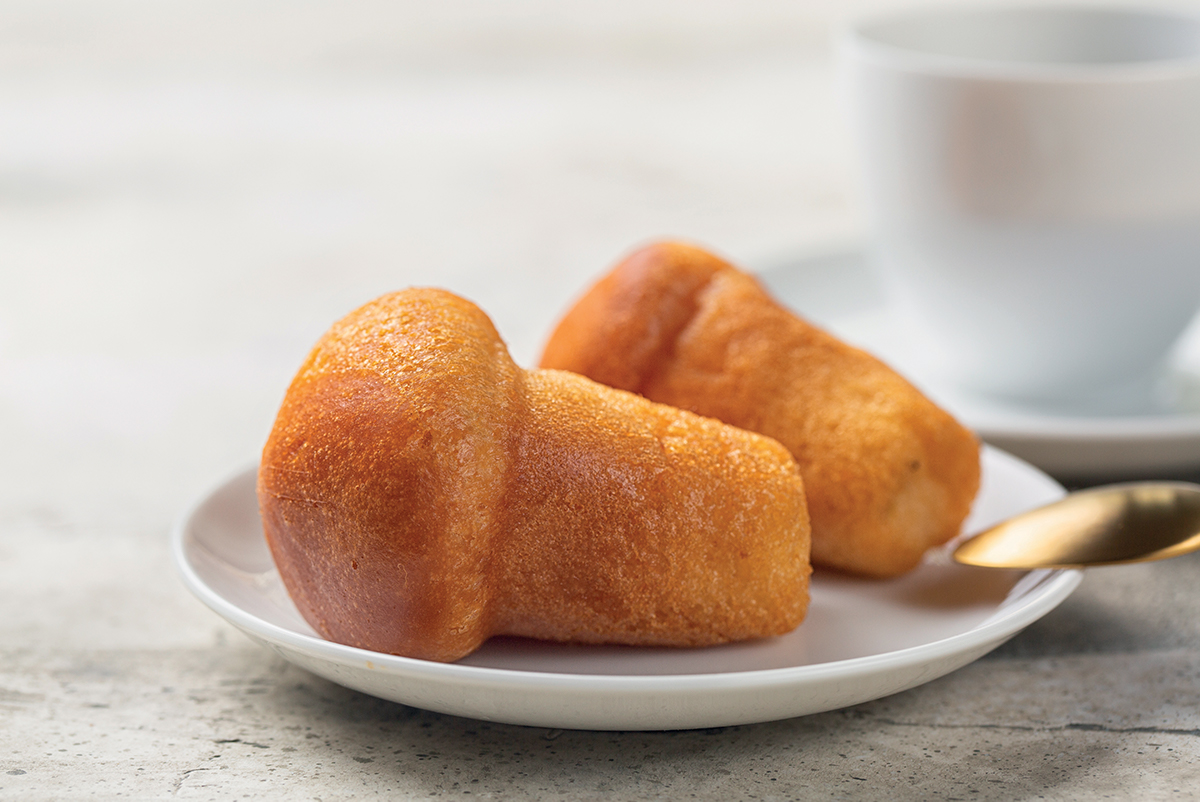 Due babà artigianali su piatto. Aromi e dolci a bassa gradazione alcolica.