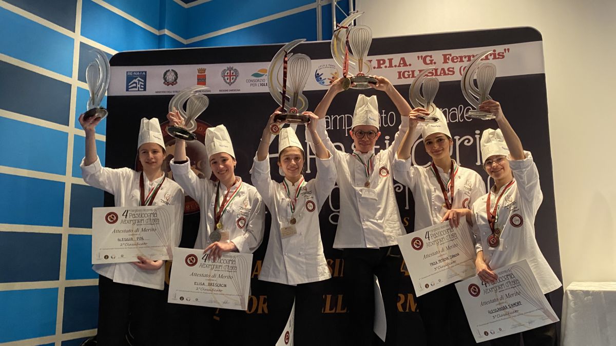 Vincitori FIPGC Campionato Nazionale Istituti Alberghieri. Giovani pasticceri con trofei e attestati sul podio.