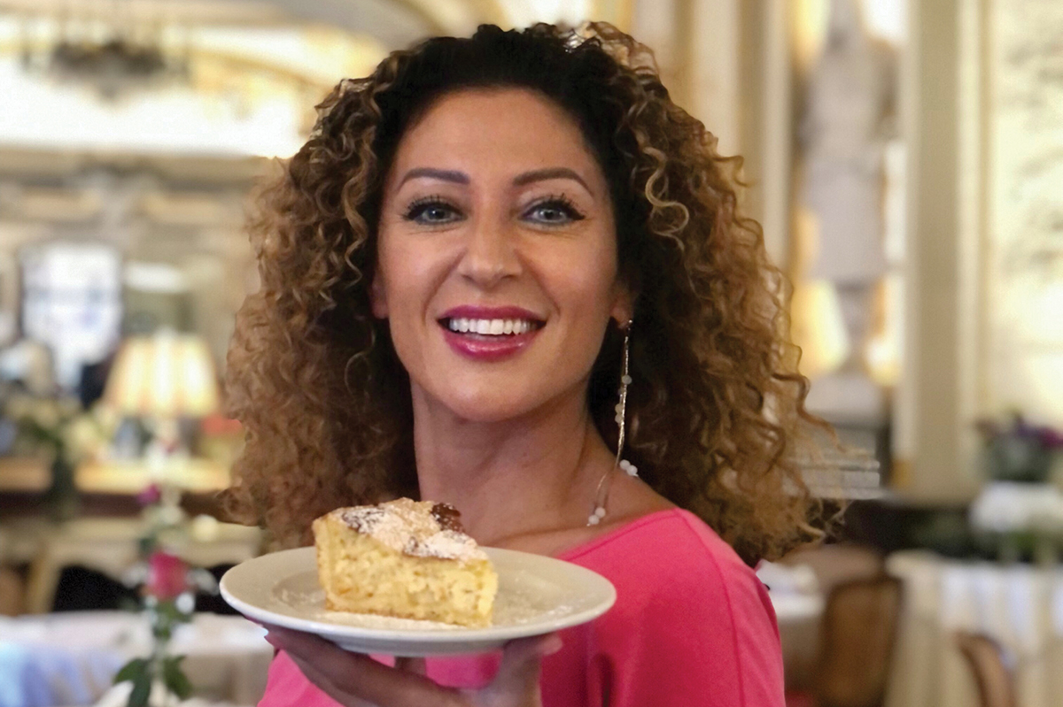 Donna sorridente con dolce del Gran Caffè Gambrinus. Pasticceria napoletana.