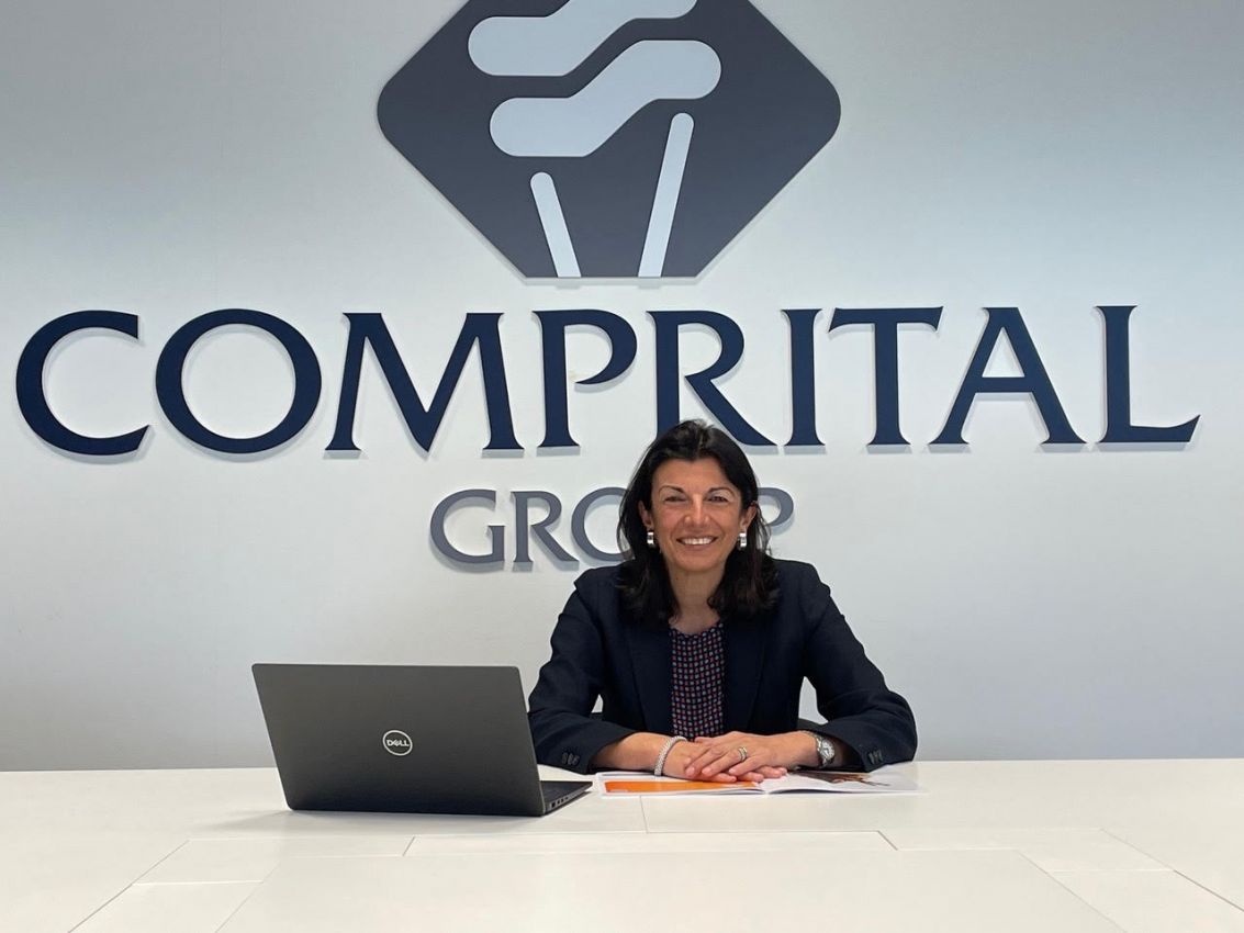 Comprital: nuovo corso. Immagine del logo Comprital e di una donna sorridente con un laptop.