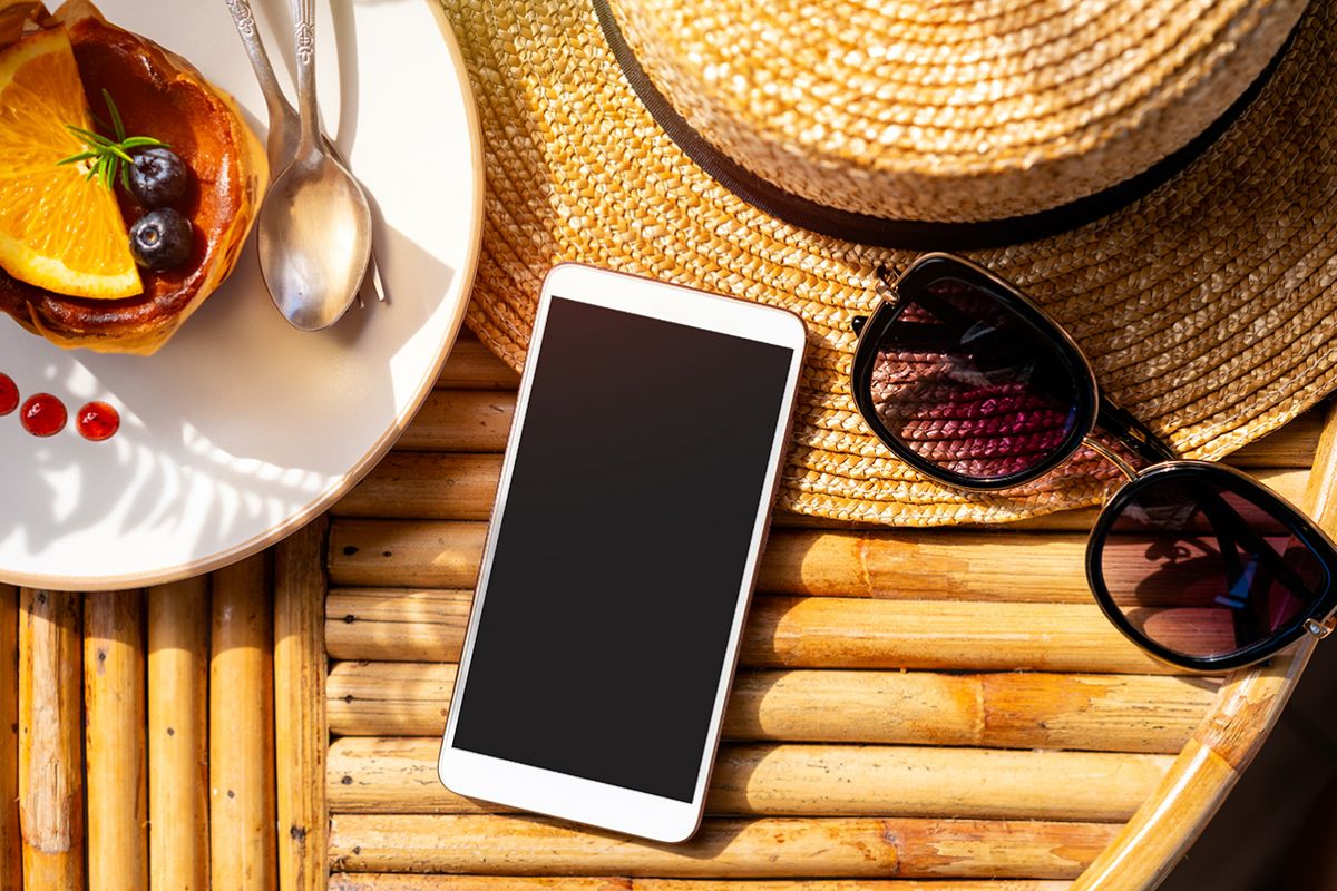 Dolce estivo con frutta, cappello, occhiali da sole e smartphone. Delizie estive dai pasticcieri italiani.