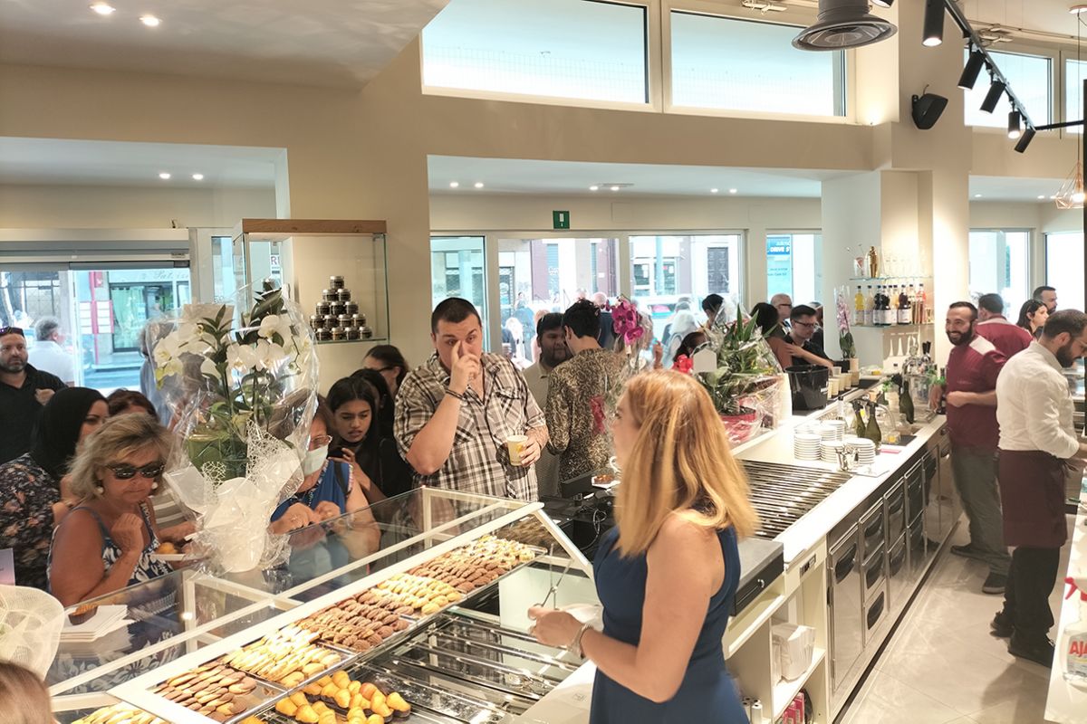 Inaugurazione La Borbonica a Bologna. Persone davanti al bancone con dolci e pasticcini. Raddoppio attività.