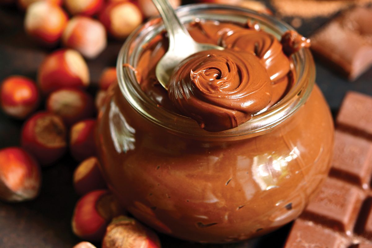 Crema spalmabile alla nocciola in barattolo con cioccolato. Golosità artigianale.