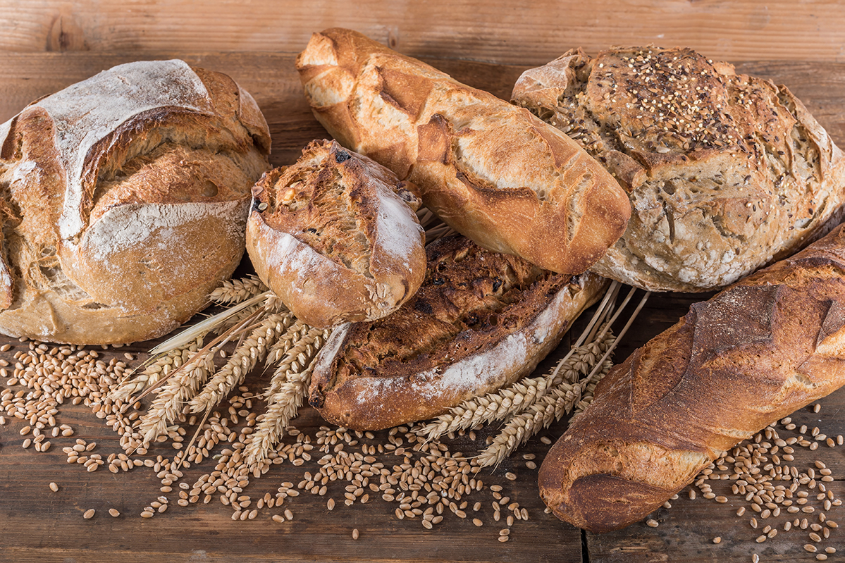 Assortimento di pane artigianale con spighe e chicchi di grano. Selezioni Italiane Mondial du Pain.