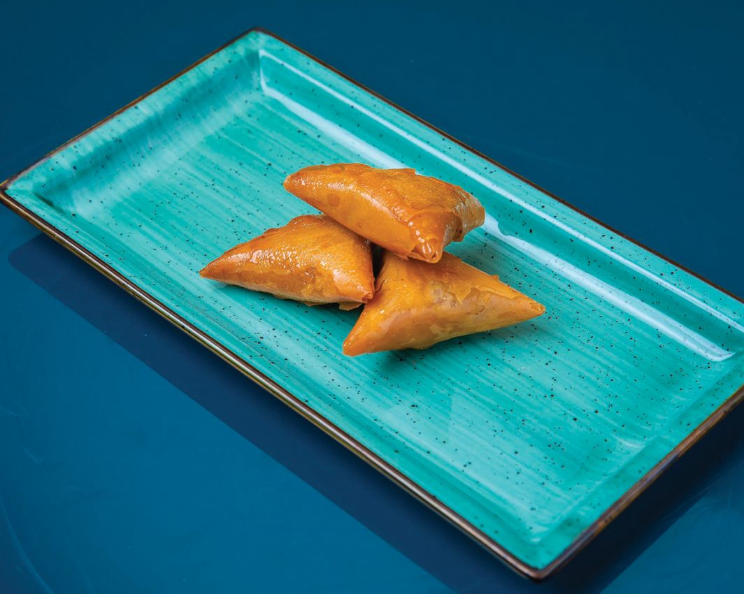 Briwat di Murad su piatto turchese. Dolci multietnici a Milano.