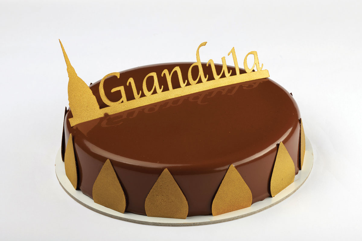 Torta Gianduja lucida con decorazioni dorate. Dolce tipico piemontese.