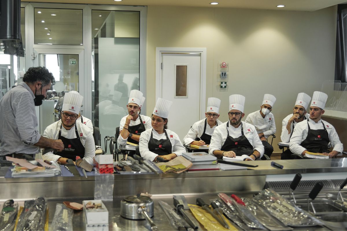 Corso di pasticceria Scuola Tessieri. Chef spiega tecniche a studenti. Laboratorio professionale, arte bianca, formazione pasticceri.