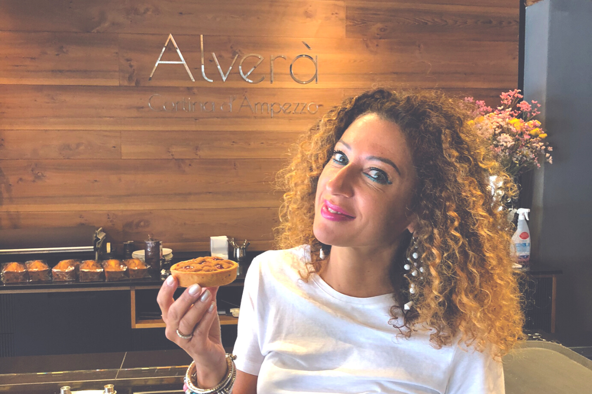 Donna con tortino Linzer di Alverà, pasticceria a Cortina d'Ampezzo. Dolci tipici, specialità locali.