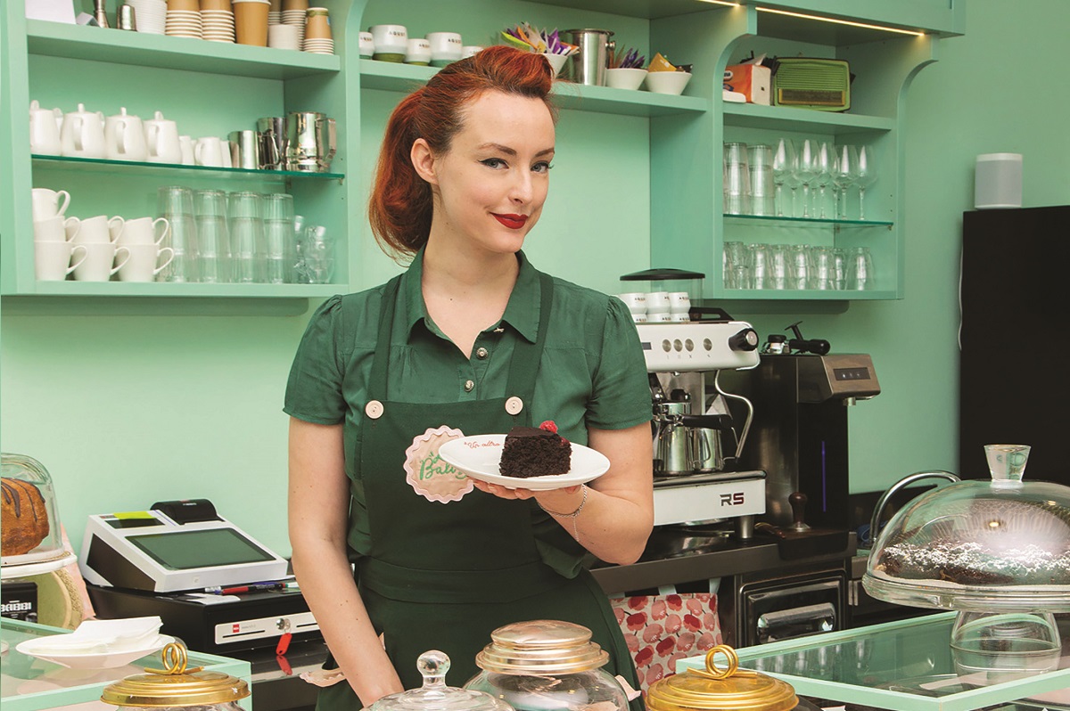 Alice Balossi, pasticcera rockabilly, offre torta al cioccolato nel suo locale.