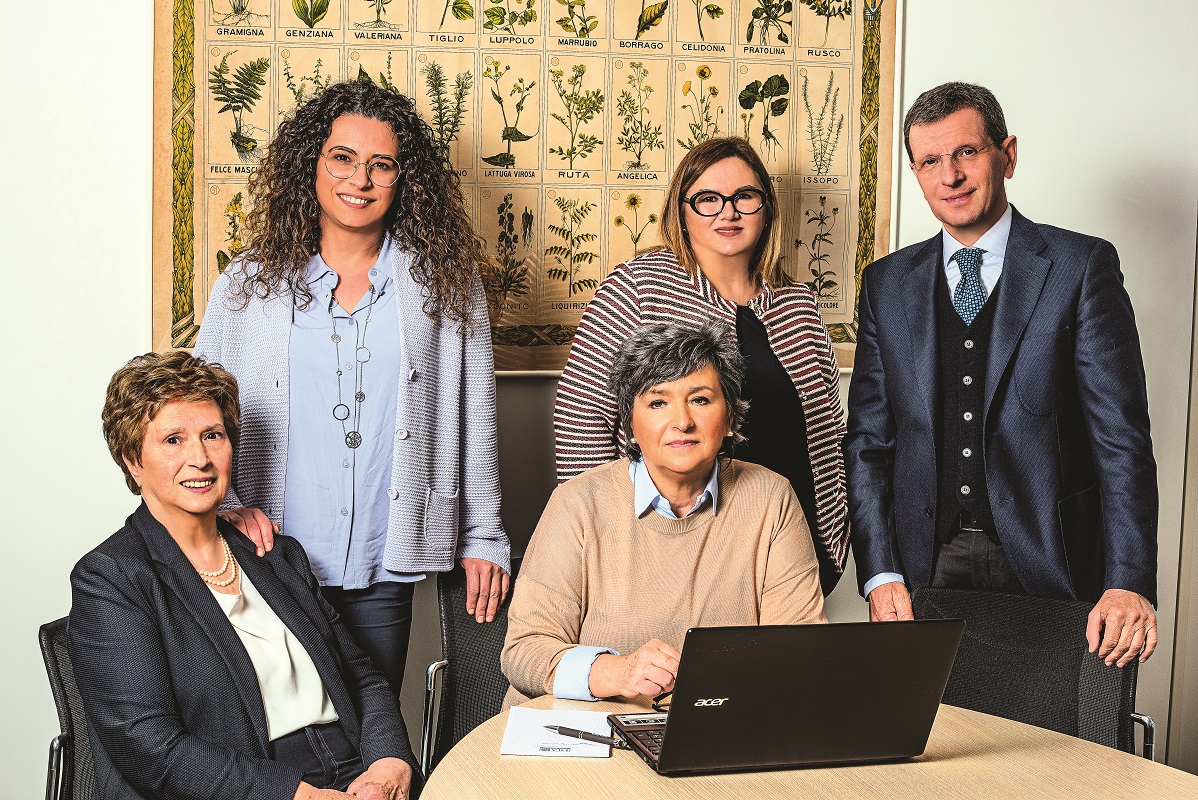 Team DIA aromi di famiglia. Persone sorridenti, poster botanico sullo sfondo. Gestione aziendale.