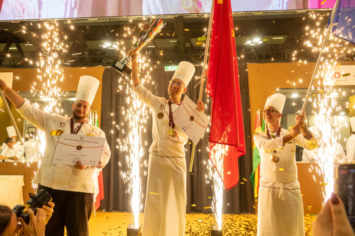 Vincitore cinese del The World Trophy of Professional Tiramisù con trofeo e bandiera cinese.