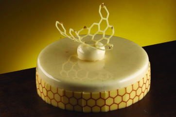 Torta Memories di Massimo Pica. Design a nido d'ape, glassa lucida e decorazioni dorate.