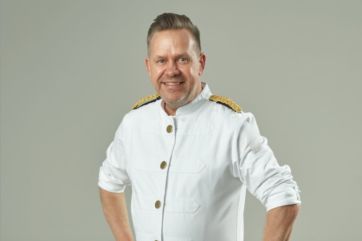 Ritratto di Roger Van Damme, chef e genio creativo in uniforme bianca da capitano.