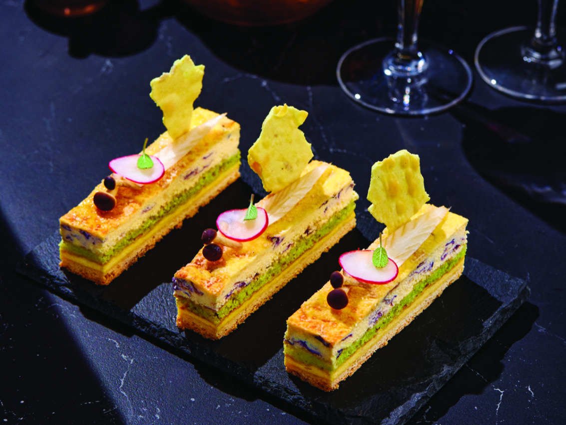 Tre tranci salati vegetariani su ardesia. Pasticceria salata con verdure fresche e chips croccanti.