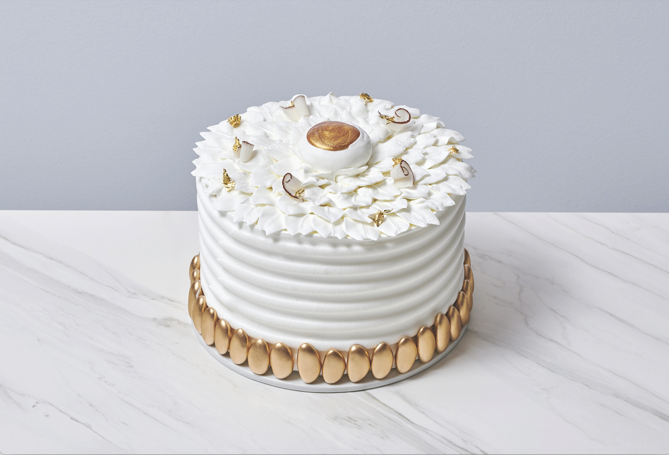 Torta esotica al cocco. Elegante torta bianca con decorazioni dorate.